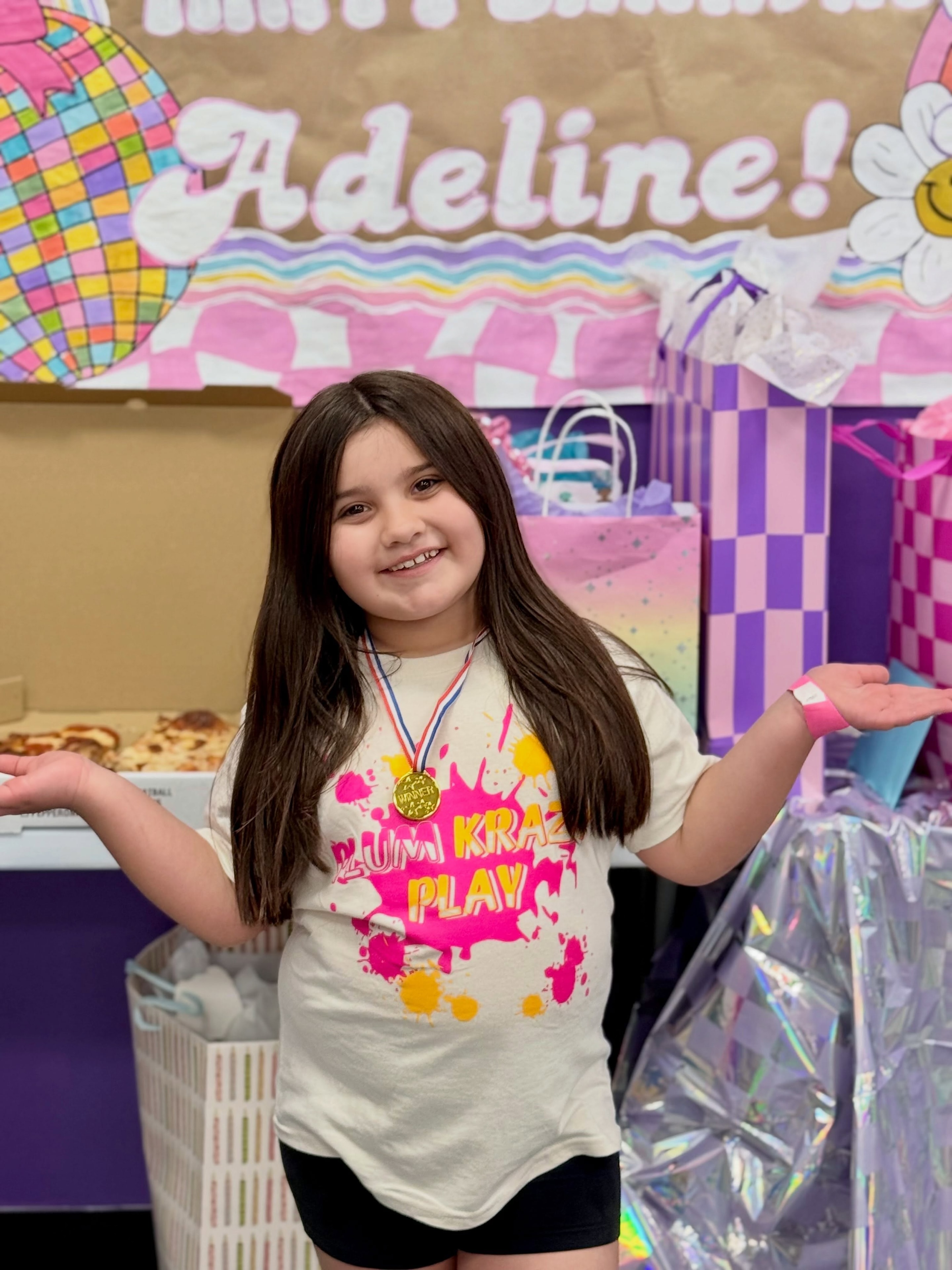 Birthday girl in a Plum Krazy Play shirt celebrating at her party
